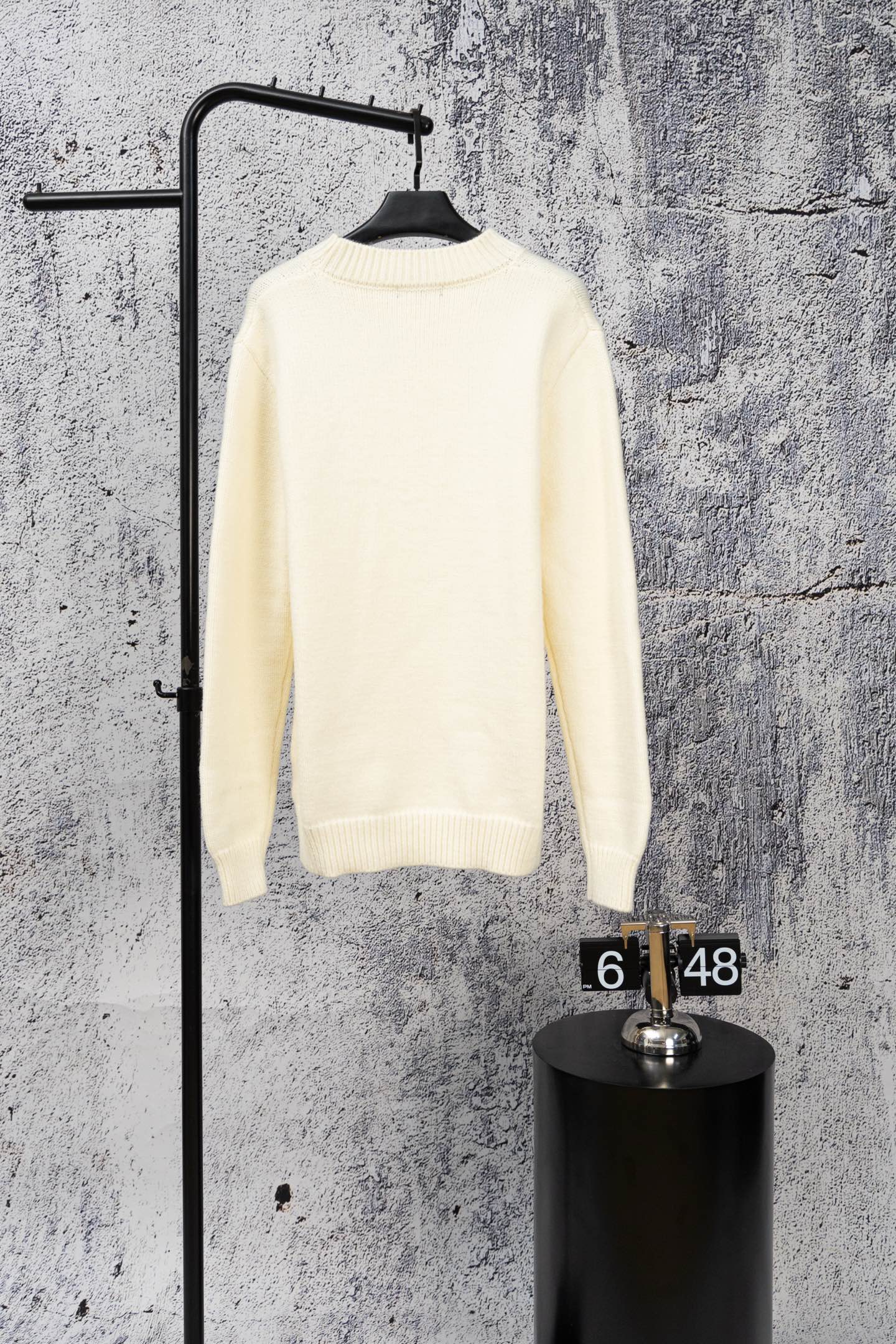 Ivory long-sleeve knit sweater on hanger with ribbed crew neck
