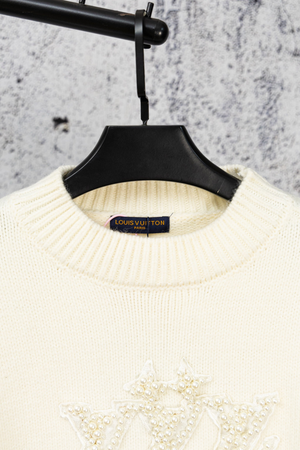 Ivory knit sweater neckline with Louis Vuitton label and beaded crest