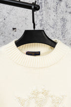 Ivory knit sweater neckline with Louis Vuitton label and beaded crest
