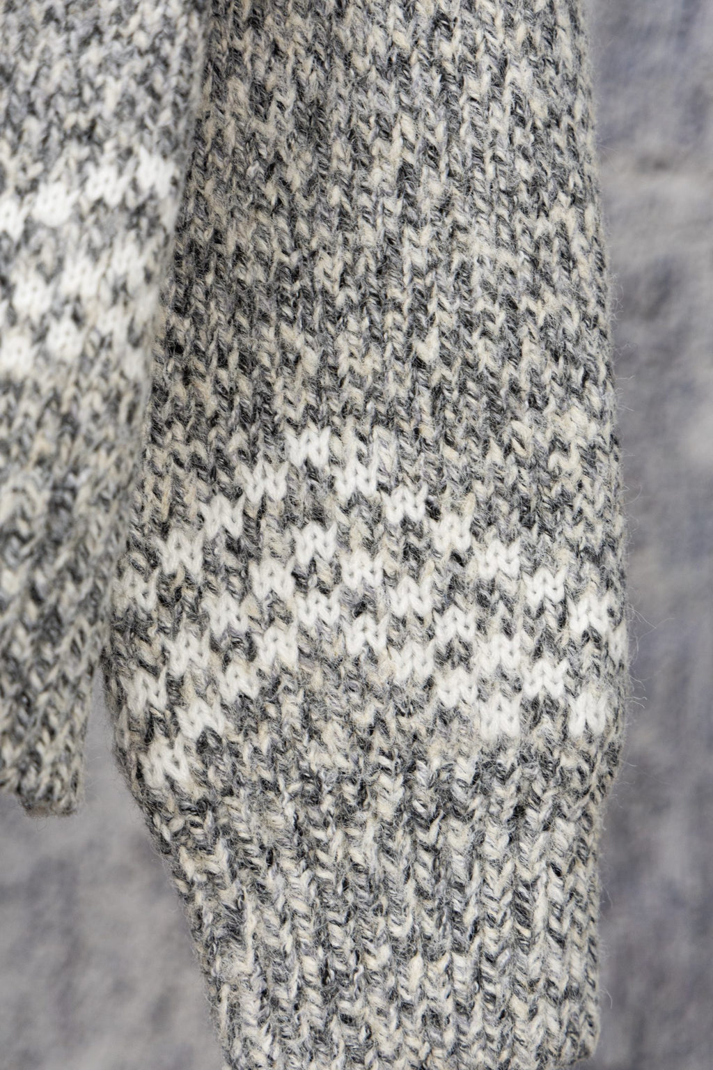 Grey speckled long-sleeve knit sweater fabric and cuff detail