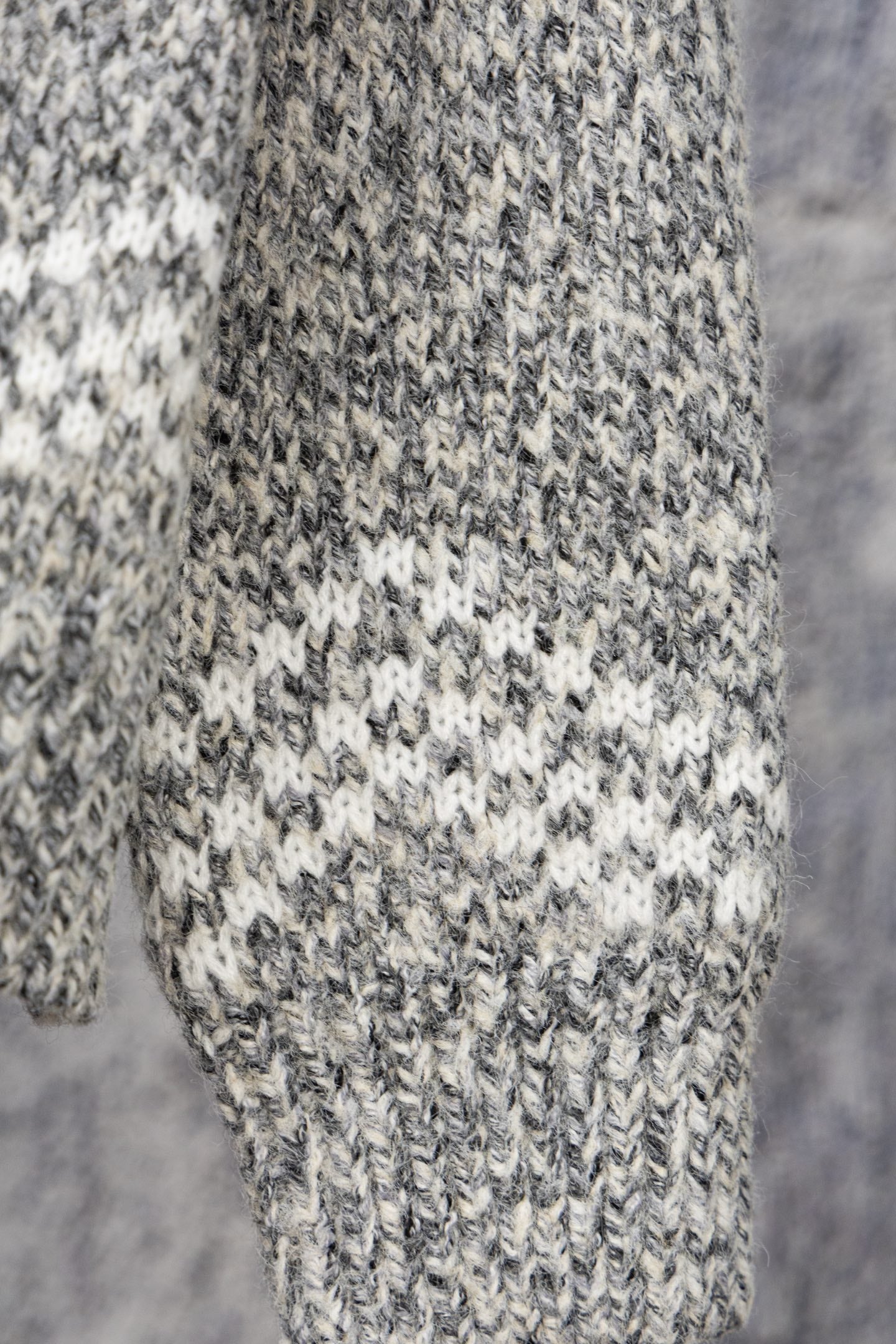 Grey speckled long-sleeve knit sweater fabric and cuff detail
