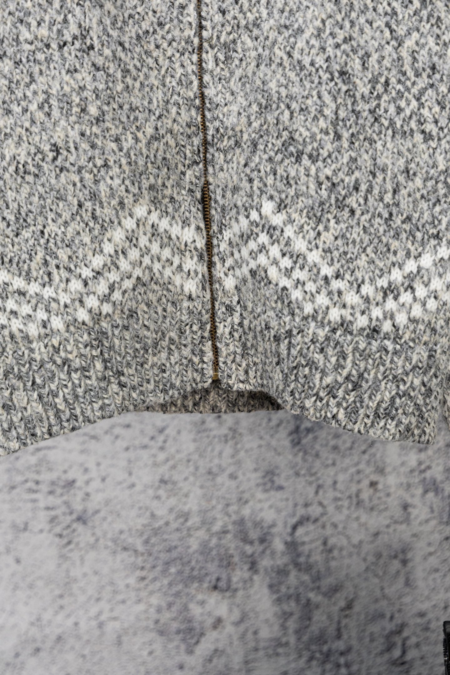 Grey knit sweater with centered zipper seam and ribbed hem