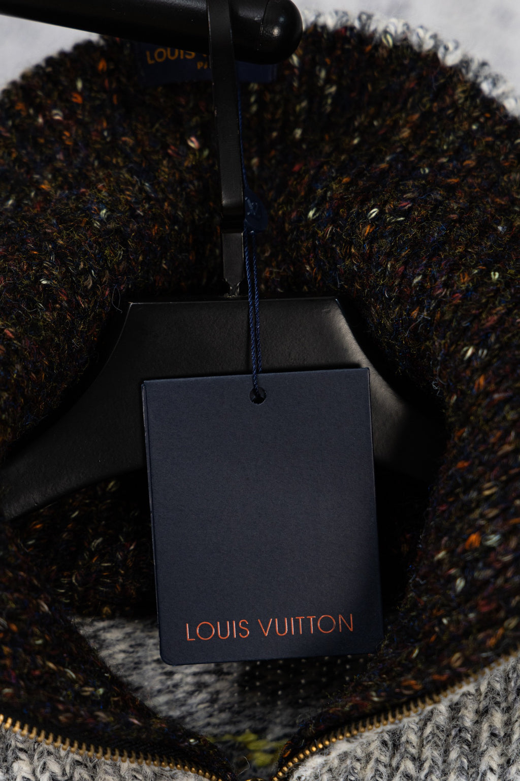 Knit sweater with Louis Vuitton shopping bag tag on display