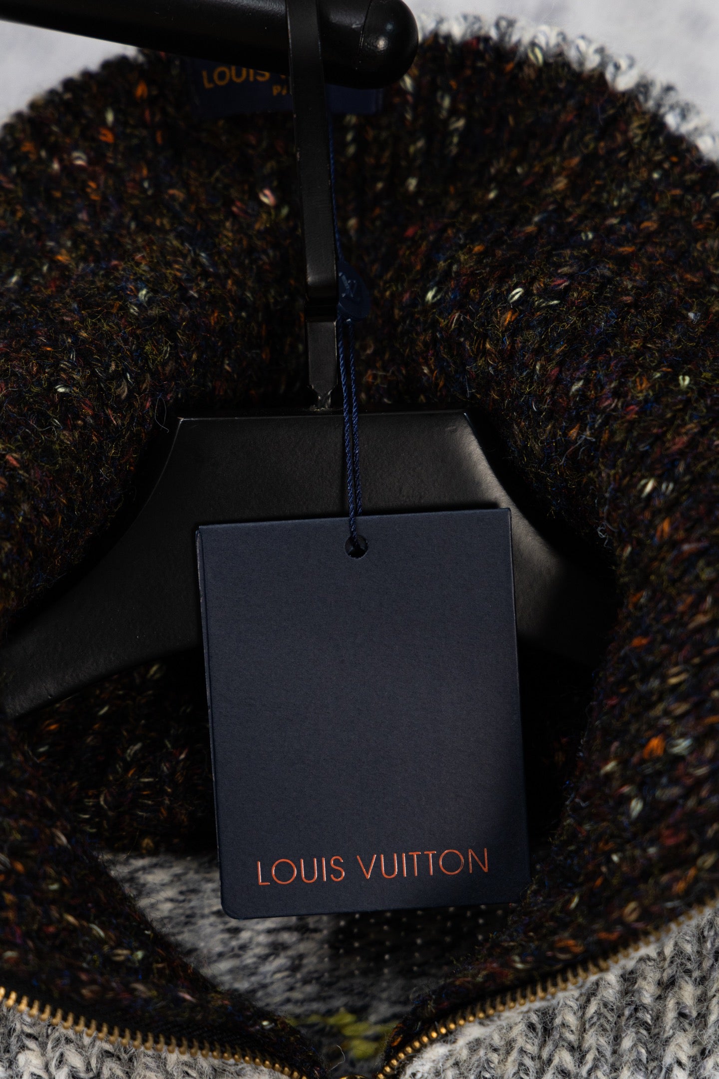 Knit sweater with Louis Vuitton shopping bag tag on display