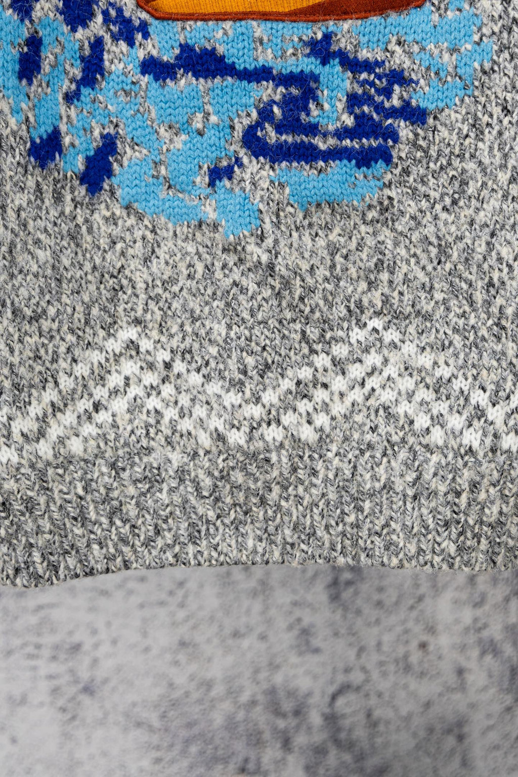 Grey knit sweater with blue and multicolor chest graphic detail