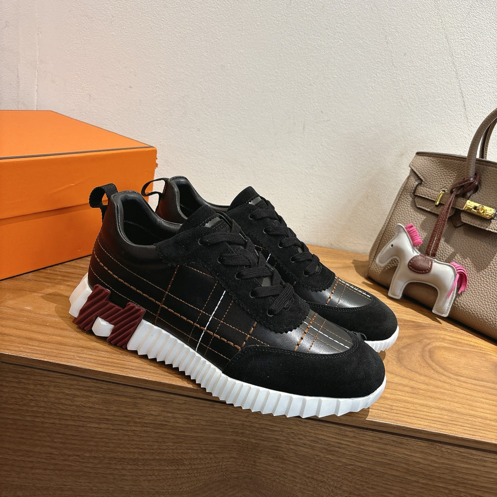 Black lace-up sneakers, side view with silver trim and thick white sole