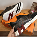 Black lace-up sneakers with striped sole and silver stitching detail