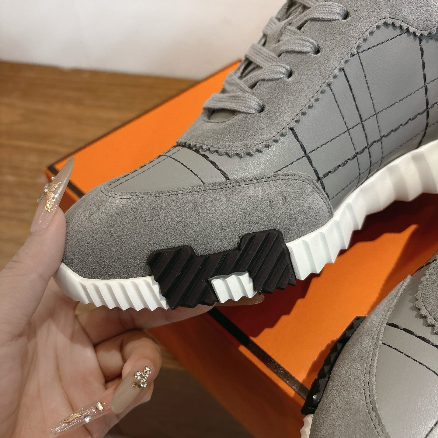 Gray sneaker toe and tread sole with white midsole and black rubber inserts.