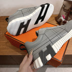 Gray sneaker soles detail with thick white midsole and black traction grooves.