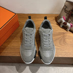 Pair of gray low-top sneakers with lace-up front and white rubber sole.