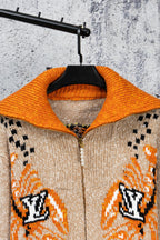 Beige knit cardigan with orange ribbed collar, patterned cuffs, full zipper front
