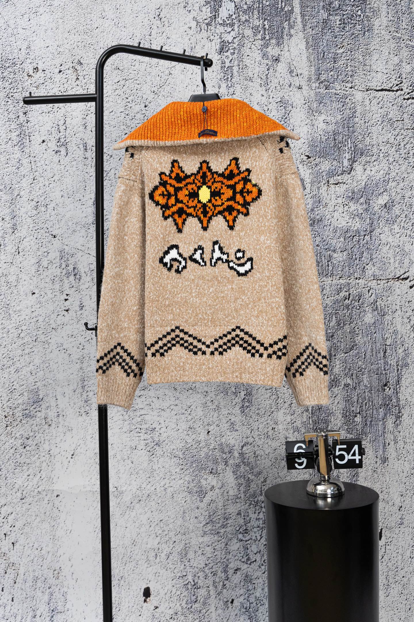 Beige knit zip-up sweater with orange hood and back orange-and-black graphic design