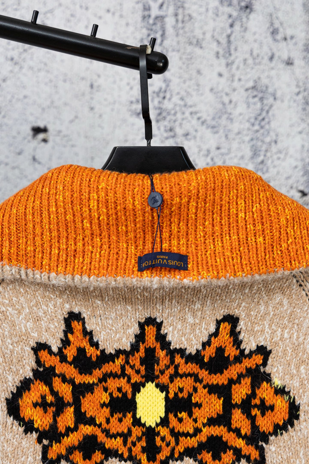 Orange knit collar sweater top with black-and-orange starburst graphic