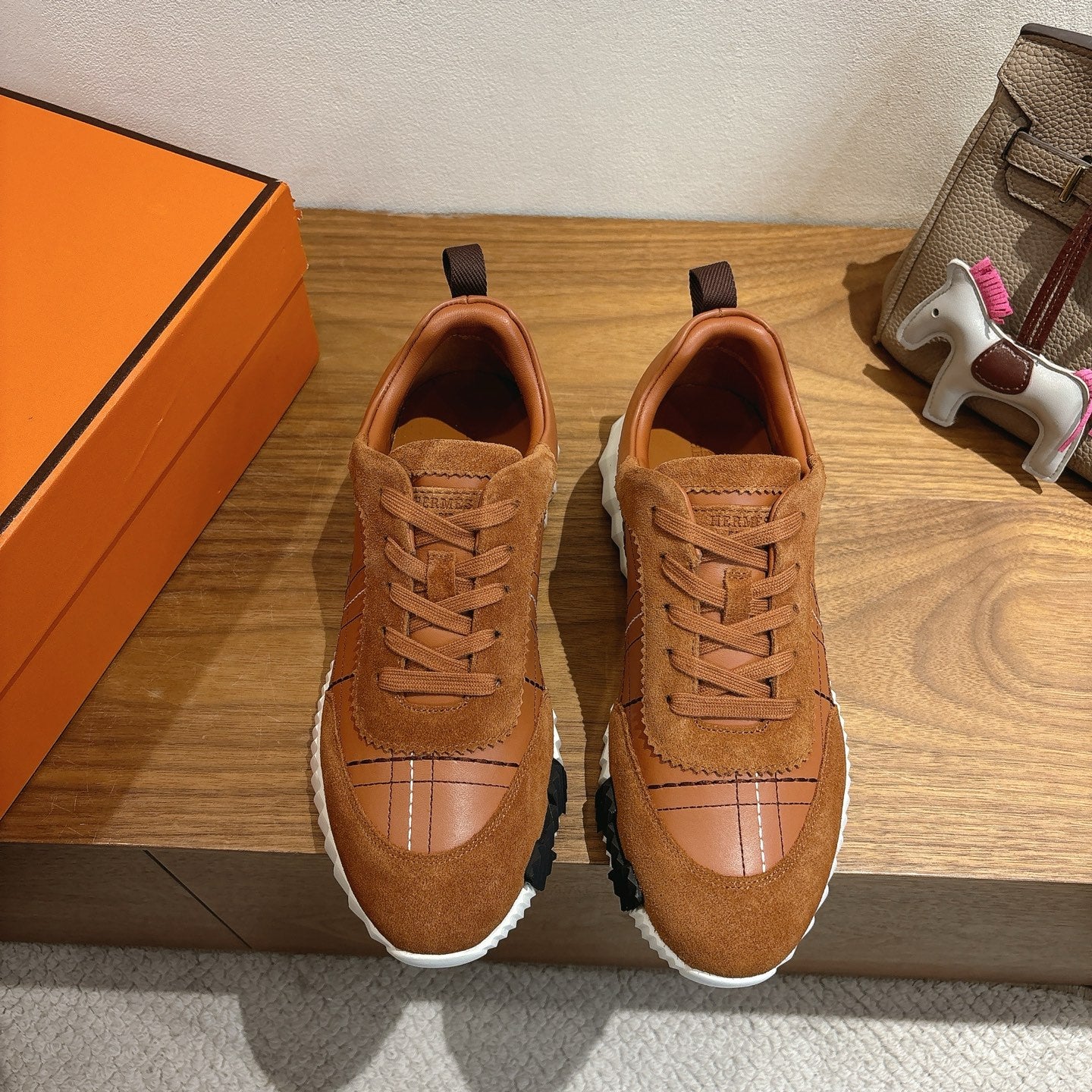 Hermes unisex sneakers, brown lace-up with paneled toe and white rubber soles.
