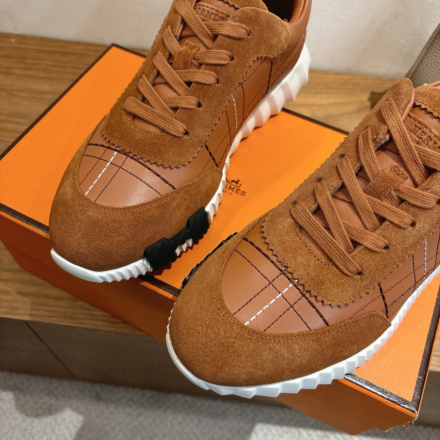 Hermes unisex sneakers detail, brown suede toe cap with grid stitching and lace-up.