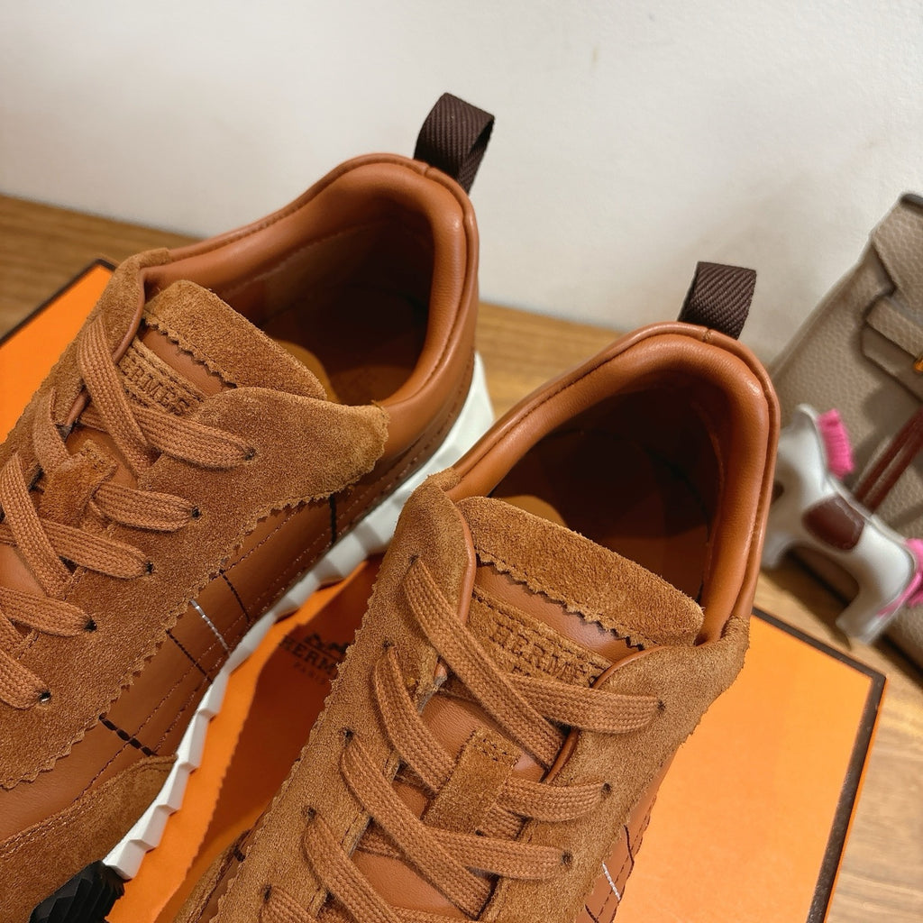 Close-up of brown suede lace-up sneakers with padded collar and detailed stitching