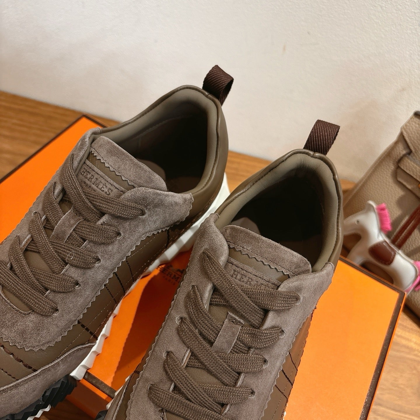 Gray lace-up sneakers close-up, showing tongue label and padded collar