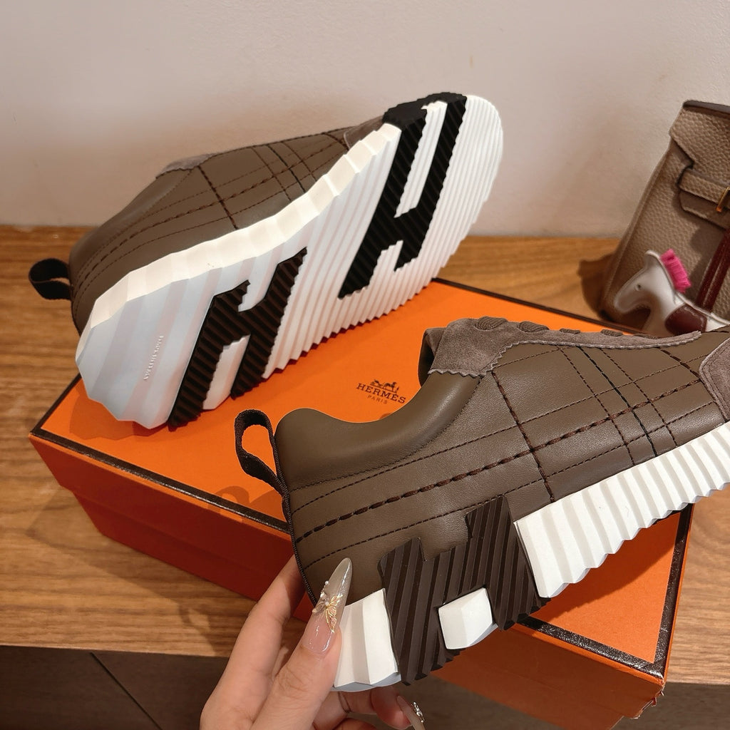 Gray sneakers with thick white-and-black striped sole and quilted side panels