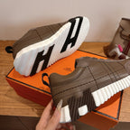 Gray sneakers with thick white-and-black striped sole and quilted side panels