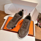 Gray lace-up sneakers inside an open box, with padded collar and rubber sole