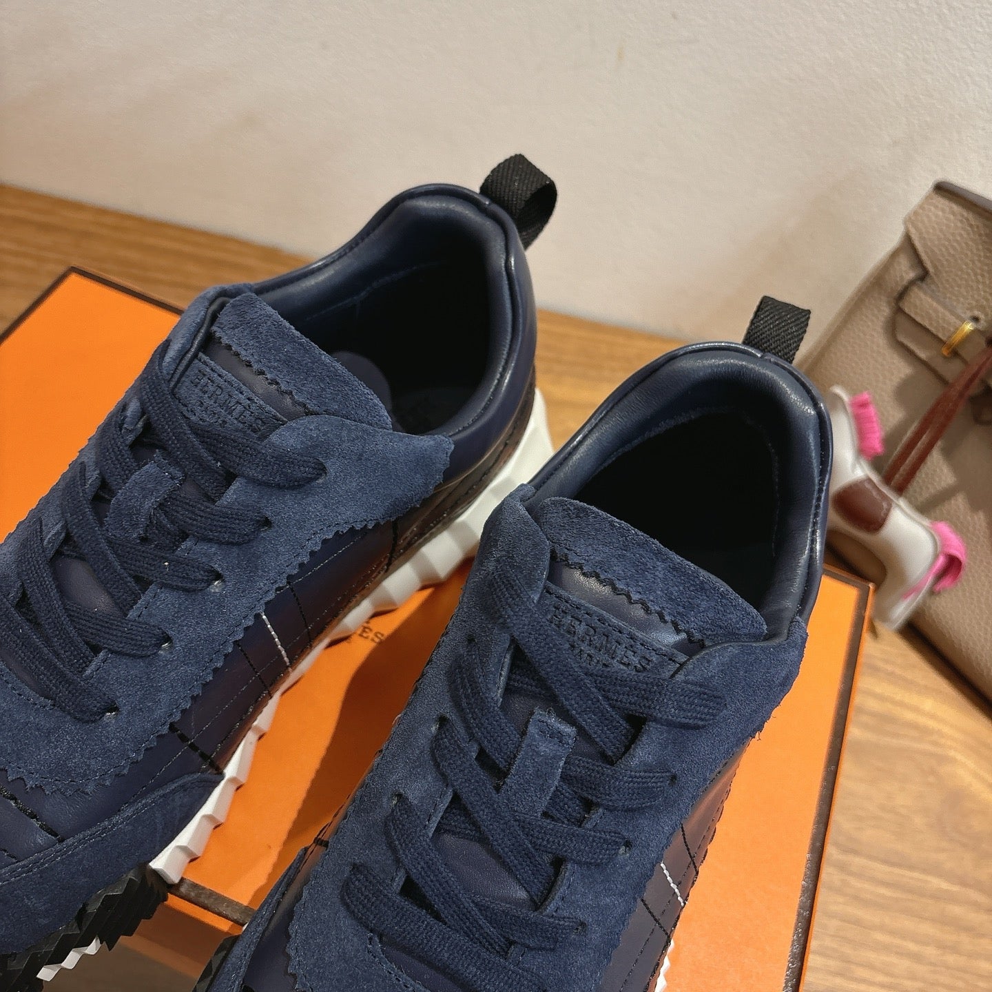 Unisex navy lace-up sneakers close-up with suede texture and silver toe panel