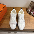 Hermes unisex white sneakers, lace-up, black grid stitching, chunky rubber sole.