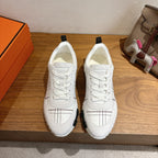 Hermes unisex white sneakers, lace-up, black grid stitching, chunky rubber sole.