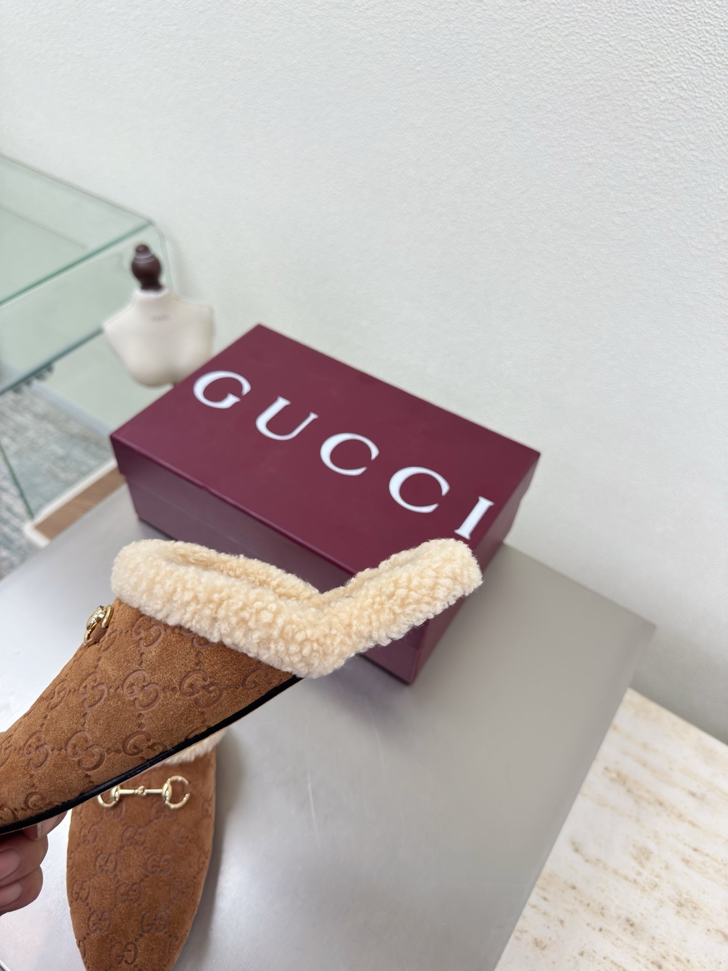 Brown suede slide mule with beige shearling strap and gold-tone horsebit detail