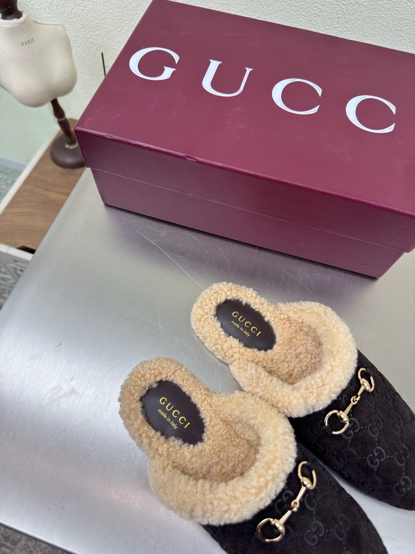 Gucci women’s slippers, dark monogram fabric with tan fuzzy trim and gold bit hardware