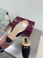 Gucci women’s slipper inside view, dark upper with tan shearling lining and size label