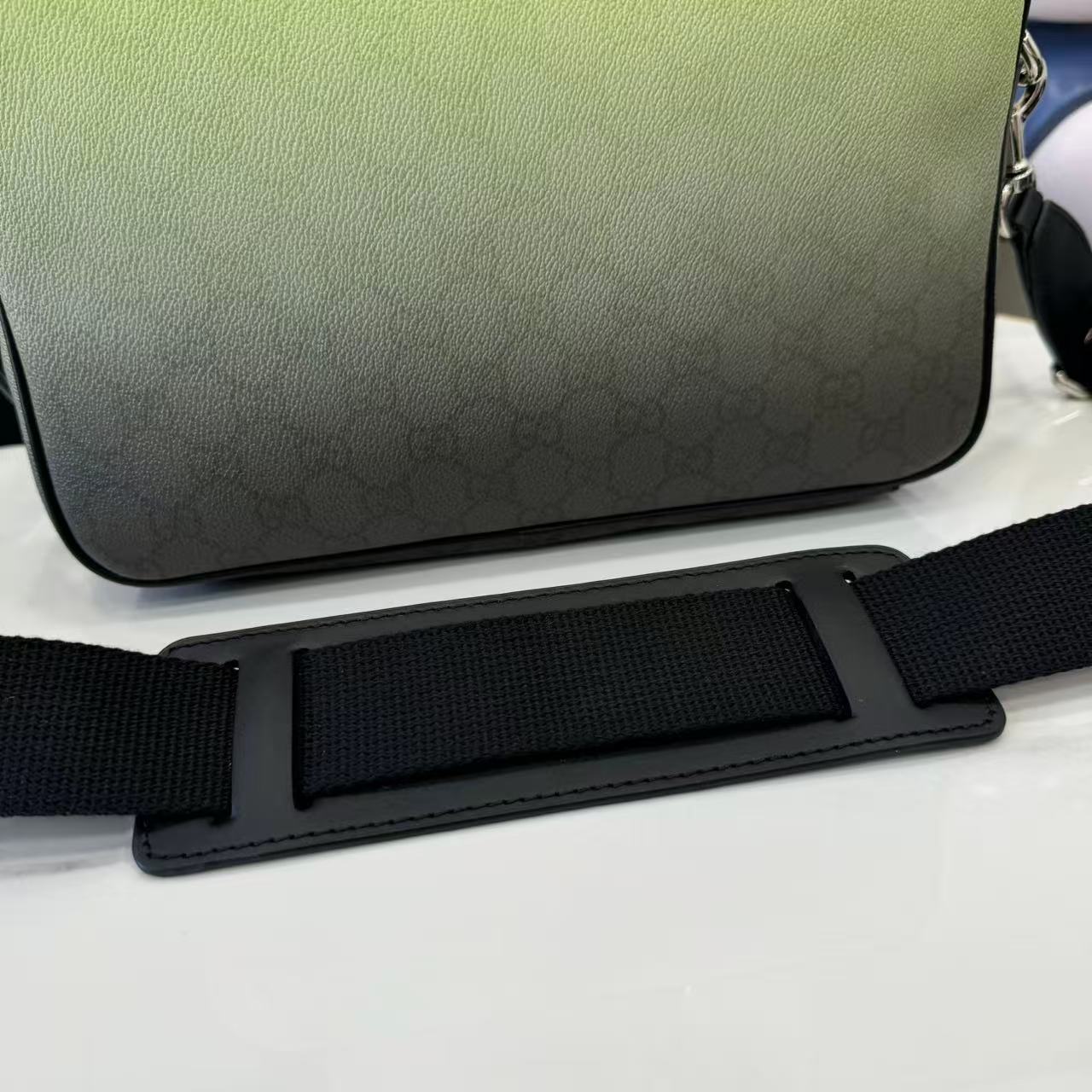 Gucci crossbody bag bottom view with lime green base and black adjustable strap.