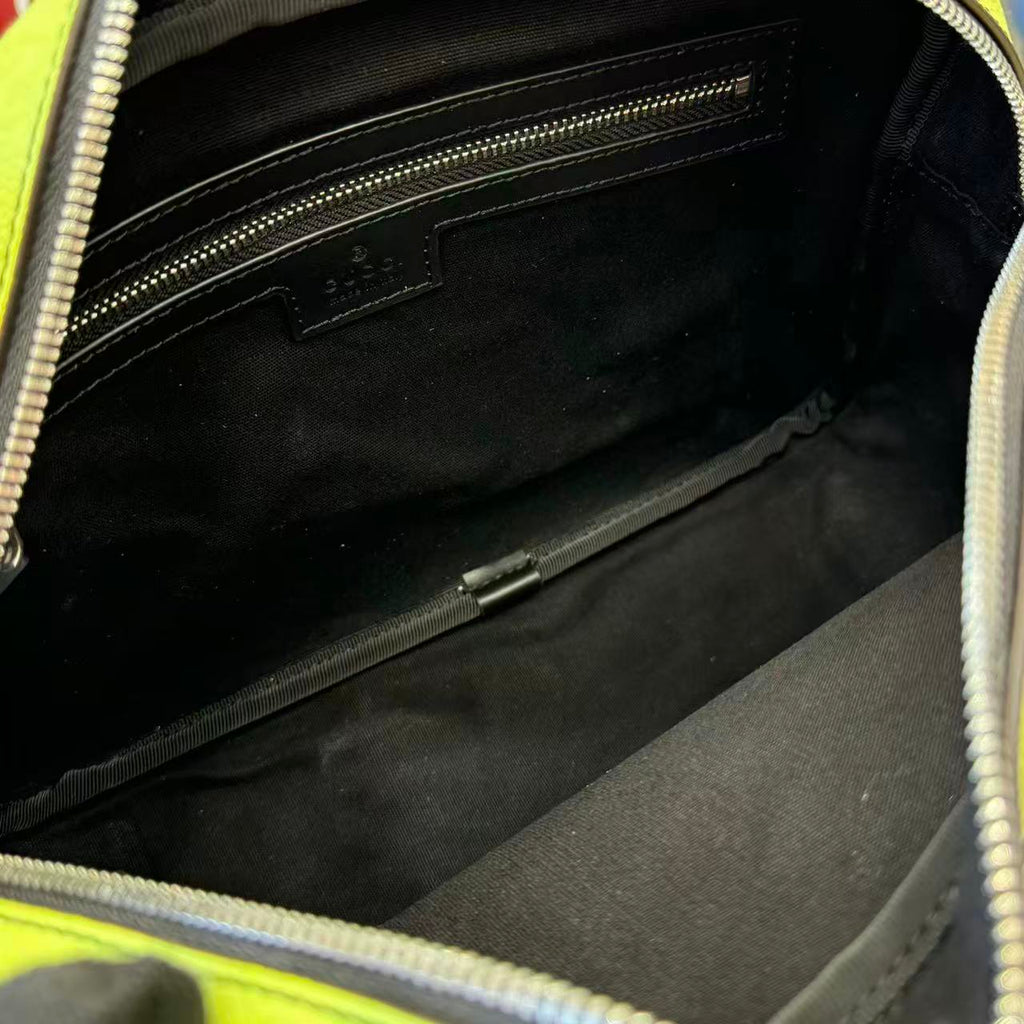 Gucci crossbody bag interior with black lining and zip pocket, lime green trim.