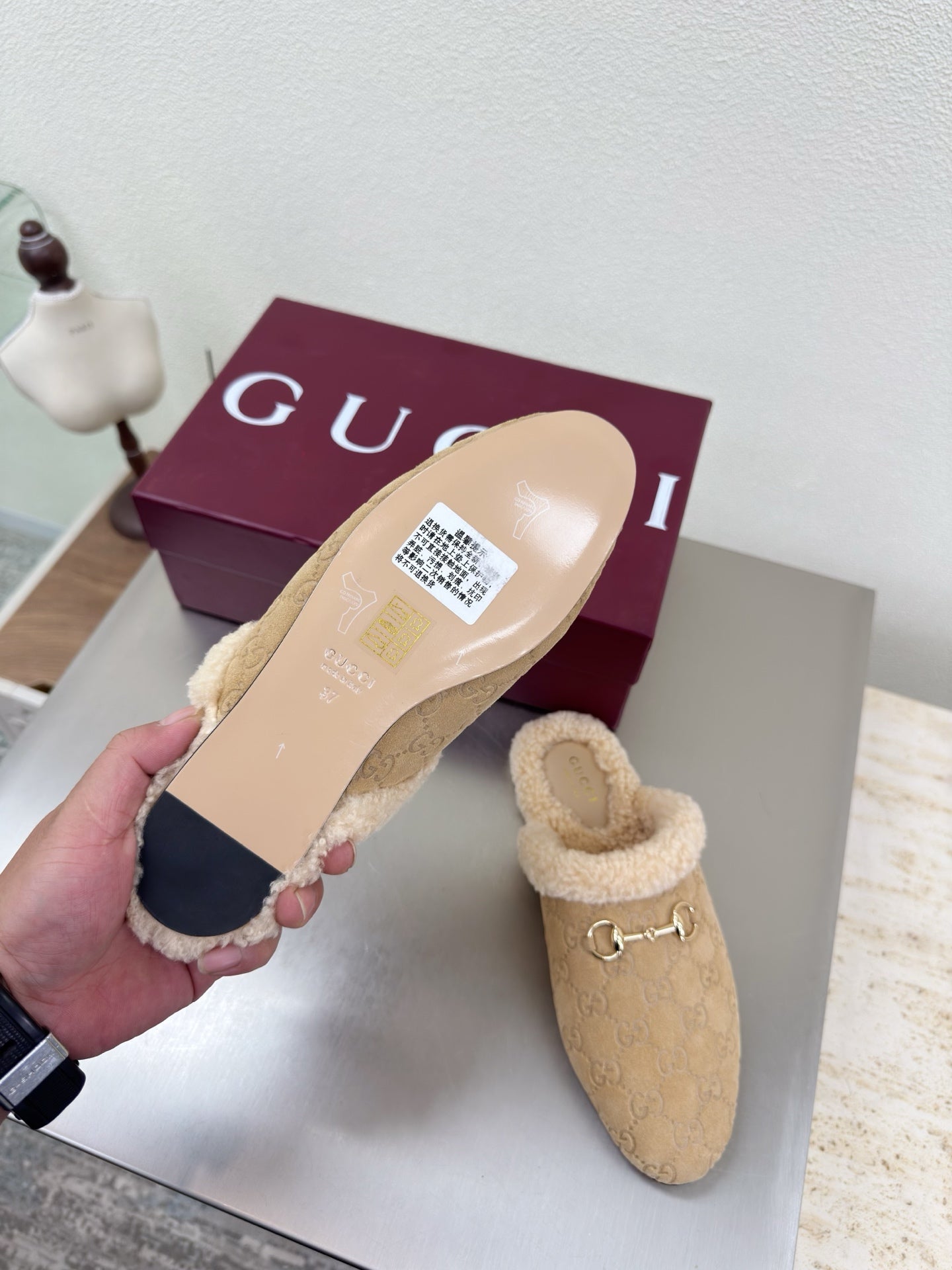 Beige mule clog showing sole and upper with tan shearling lining and gold horsebit detail