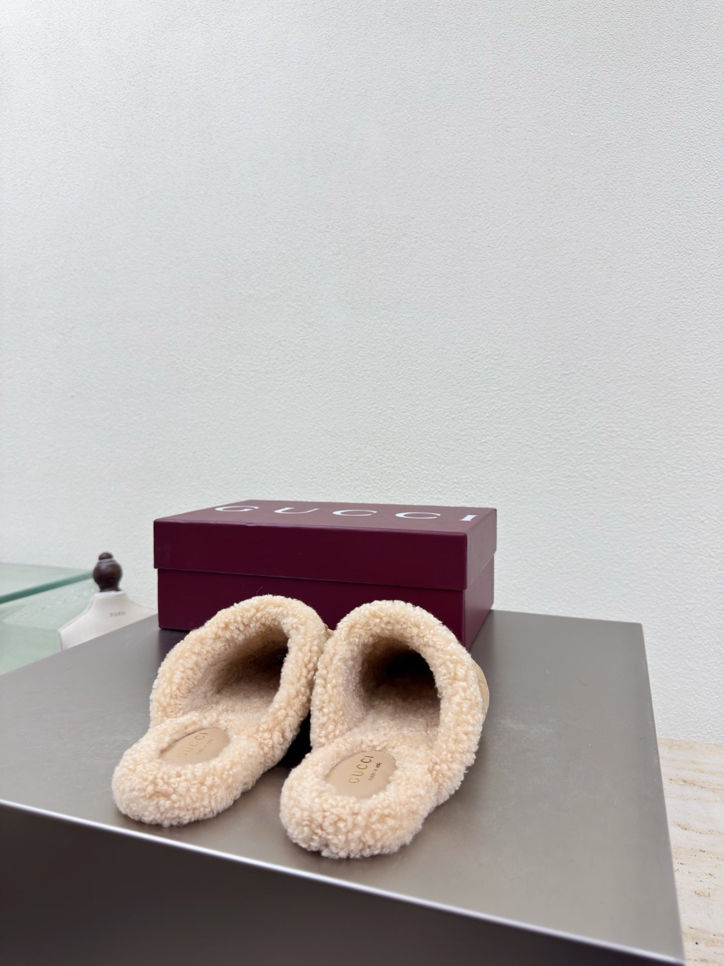 Beige shearling-lined mule clogs with gold horsebit detail and GG monogram upper