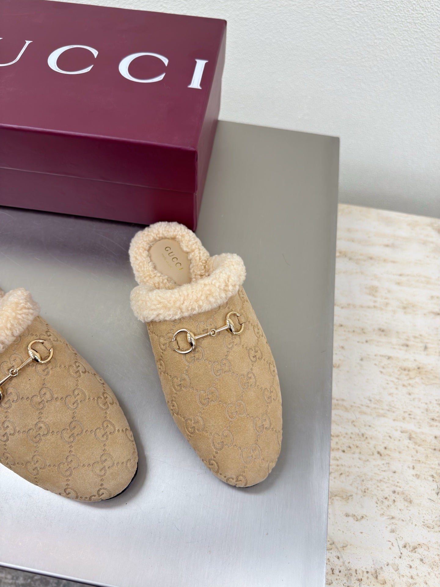 Beige GG monogram slip-on clogs with tan shearling trim and gold horsebit accent