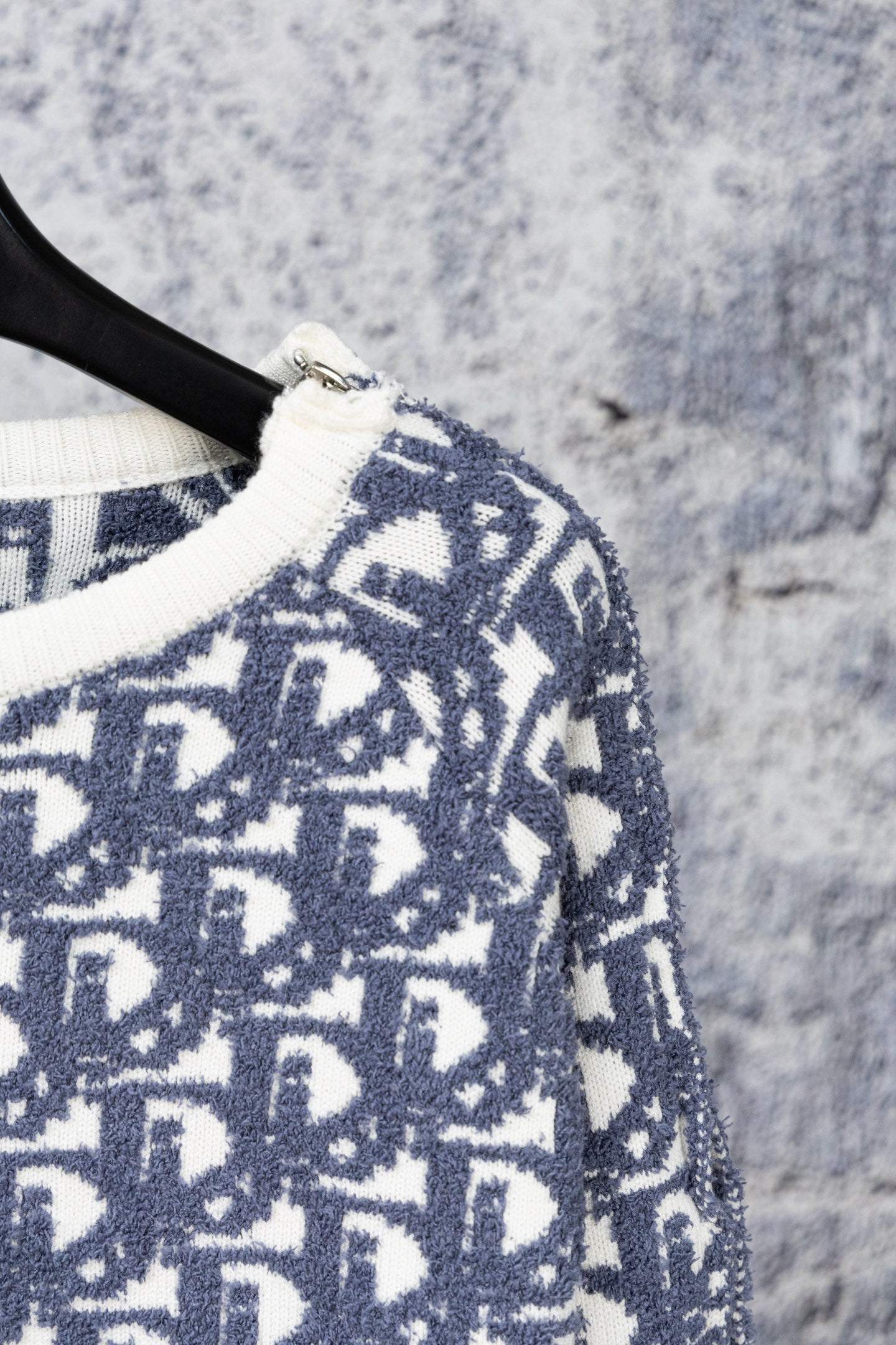 Close-up of Dior monogram knit sweater sleeve with ribbed cuff trim
