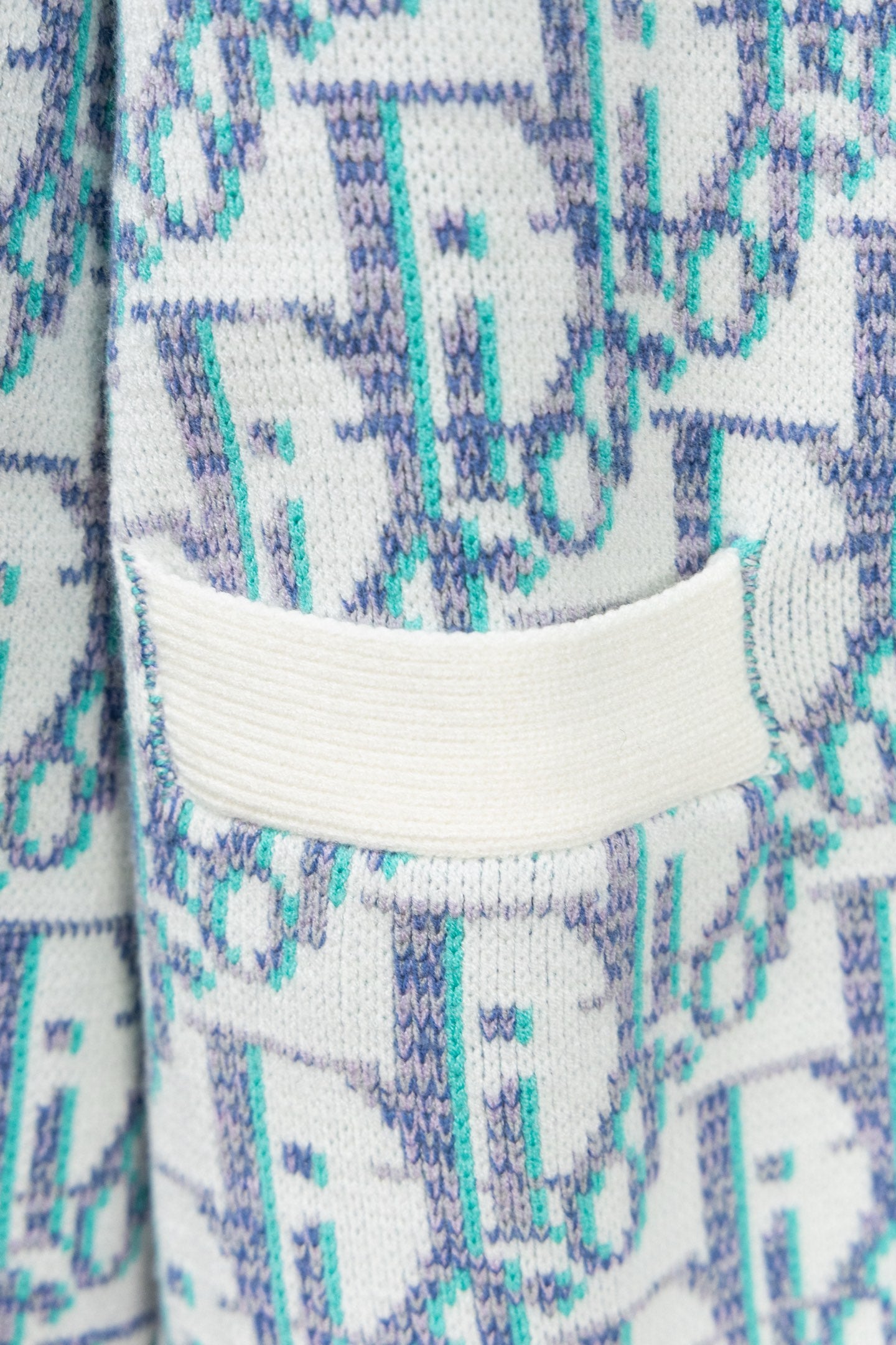 Cardigan collar close-up with white ribbed trim and blue patterned knit