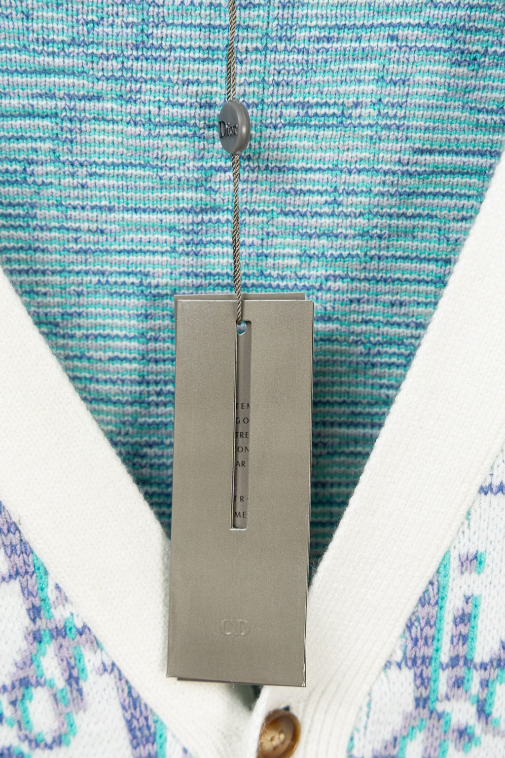 V-neck cardigan neckline close-up with blue textured knit and white trim