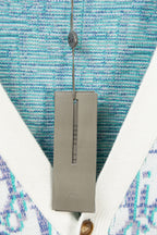 V-neck cardigan neckline close-up with blue textured knit and white trim