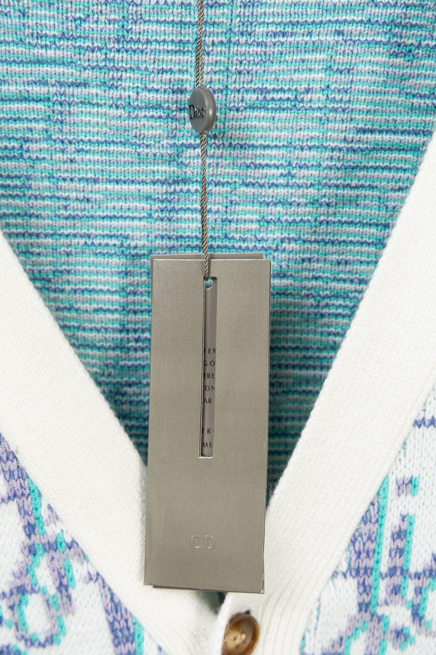 V-neck cardigan neckline close-up with blue textured knit and white trim