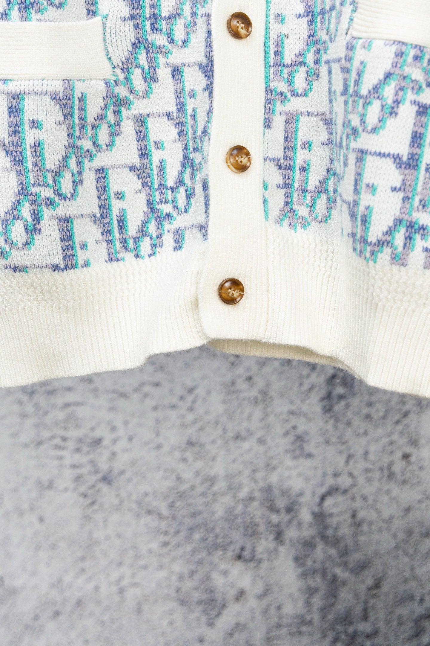 Knit cardigan close-up with gold-tone buttons on white placket