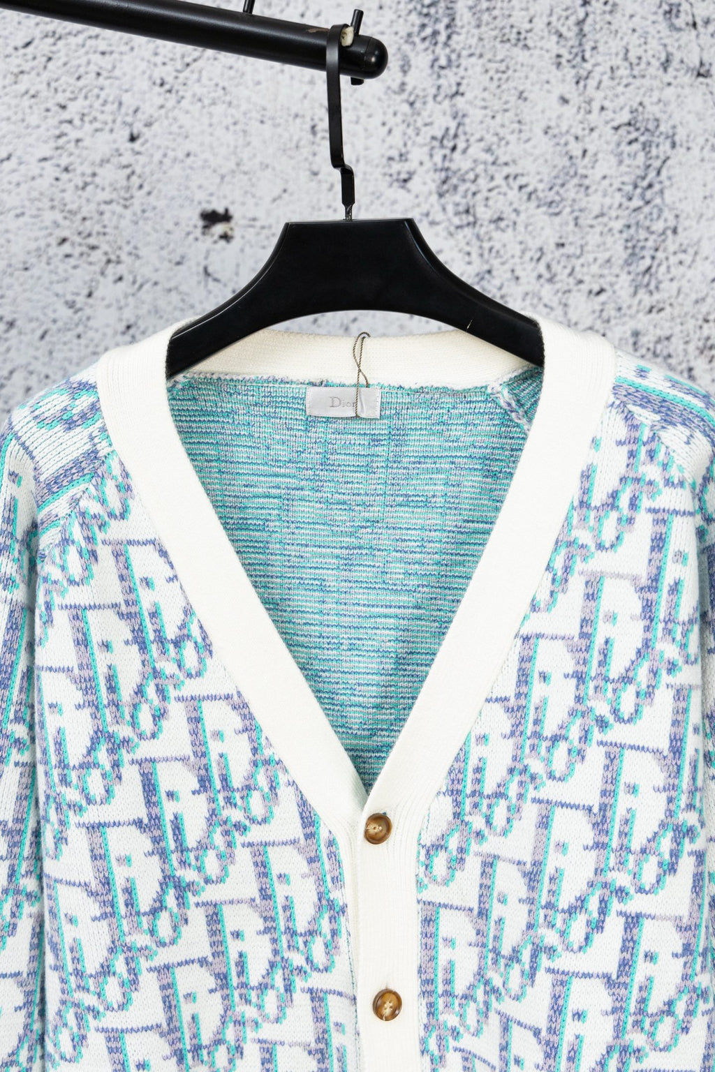 Backless view of V-neck knit cardigan with blue interior panel and button placket