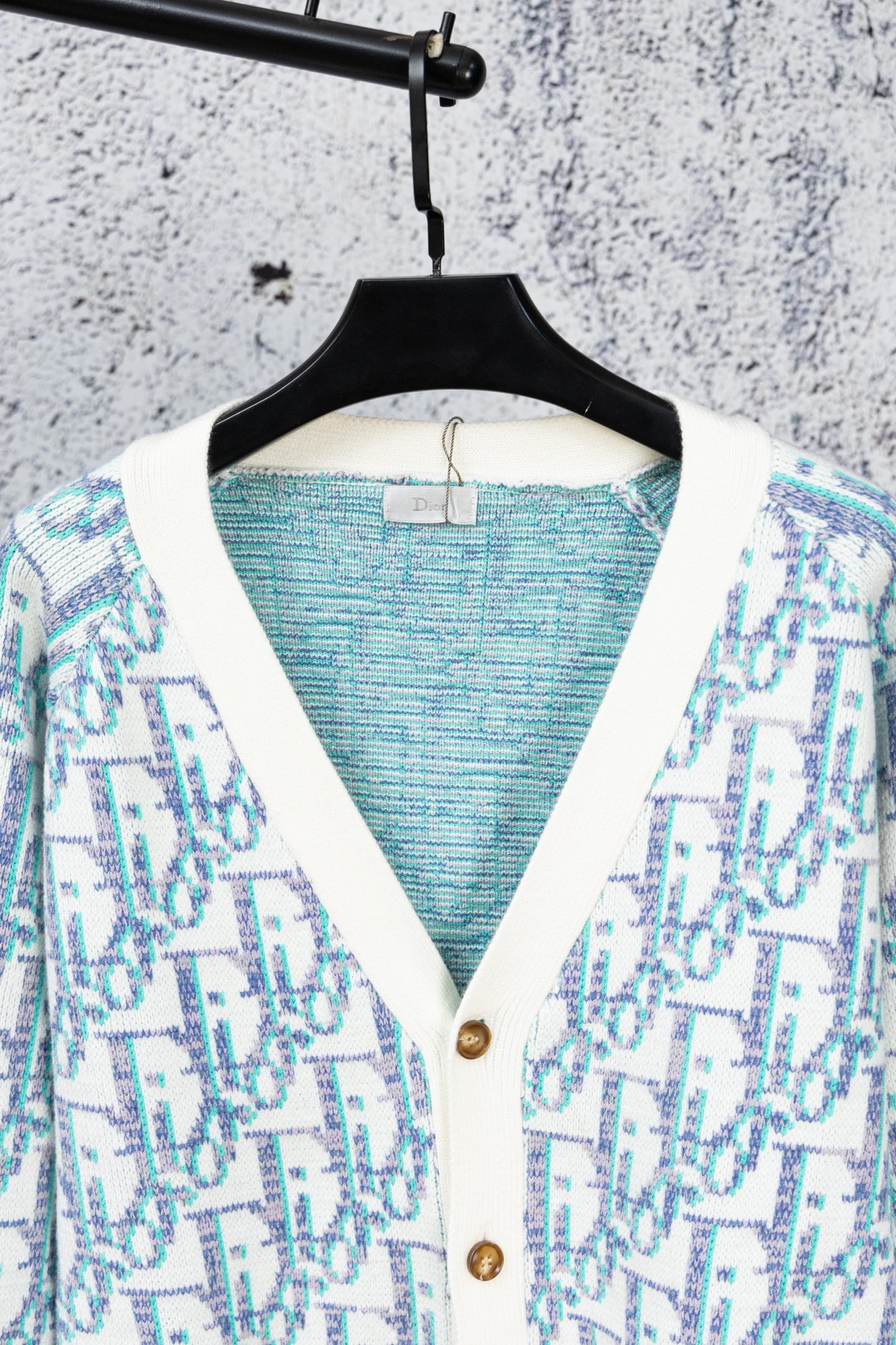 Backless view of V-neck knit cardigan with blue interior panel and button placket