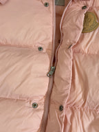 Moncler long puffer jacket, close-up of front zipper and snap buttons on pink fabric