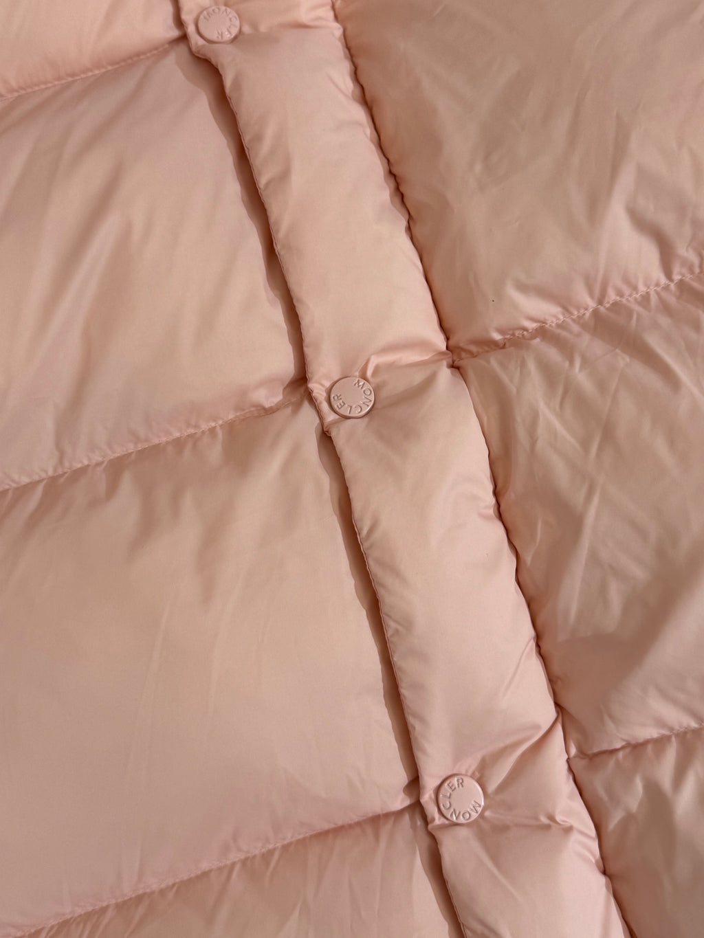 Moncler long puffer jacket, close-up of quilt seams and snap-button placket