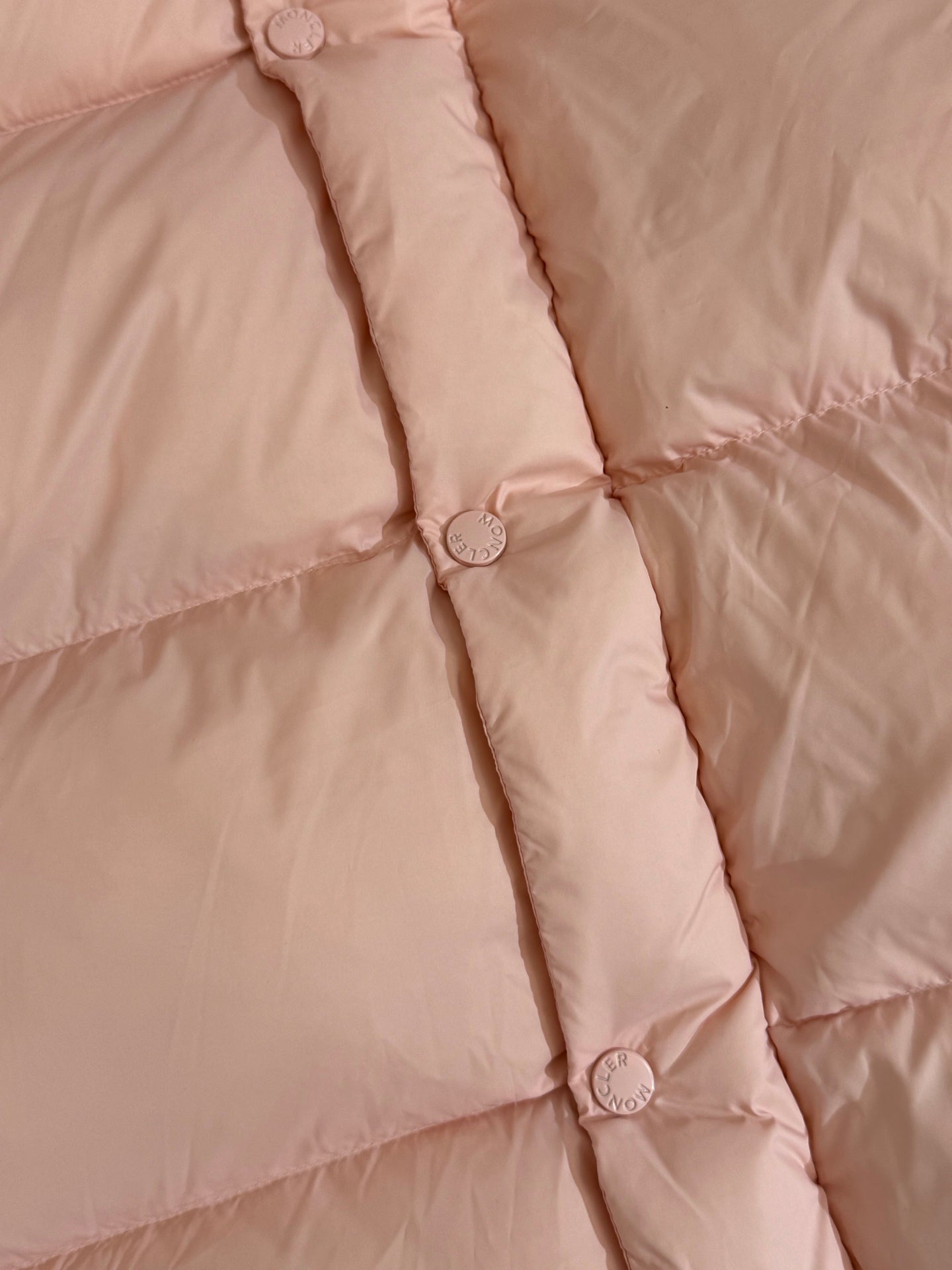 Moncler long puffer jacket, close-up of quilt seams and snap-button placket