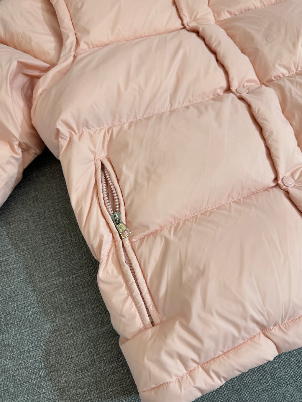 Moncler long puffer jacket, close-up of side zip pocket on pink quilted sleeve