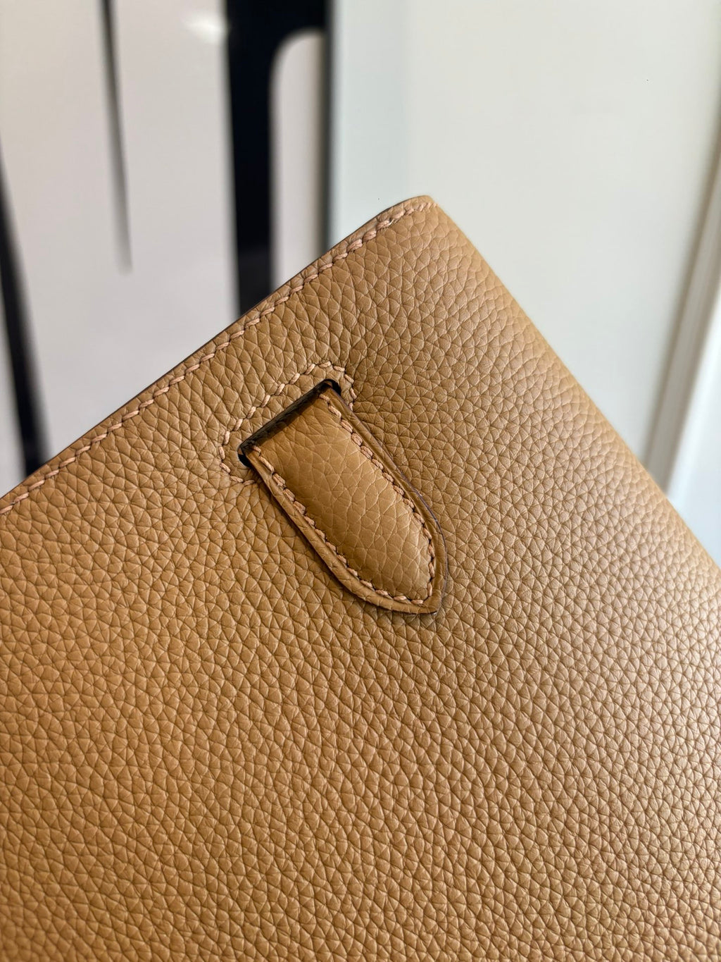 Hermes tan leather bag close-up of flap detail and stitching