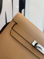 Hermes tan leather bag close-up of front strap and metal lock
