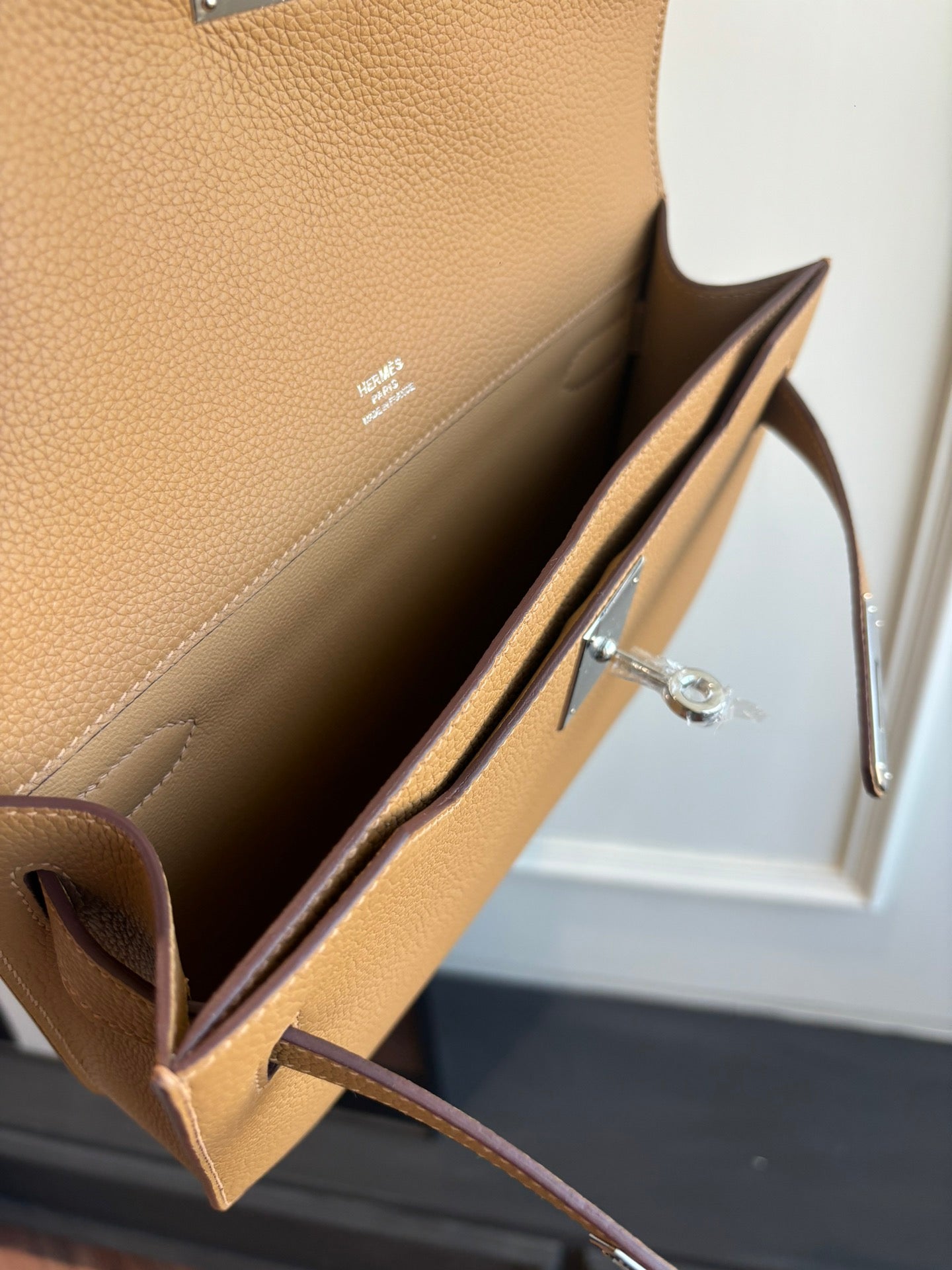 Hermes tan leather bag open view with interior pocket and metal clasp